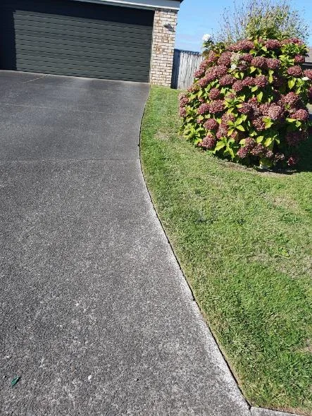 Clean driveway edge beside tidy lawn